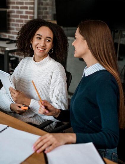 female-colleagues-talking-each-other-during-meeting